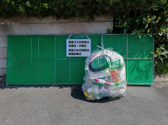 収集日の案内板が掛かった集積所に出されたごみ袋